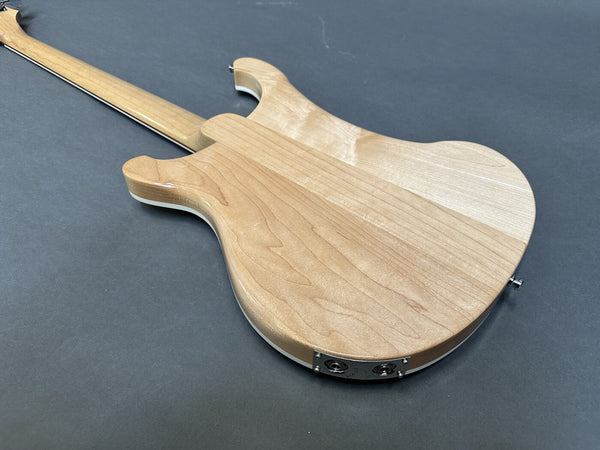 Back view of natural wood electric guitar body with dual output jacks on gray background