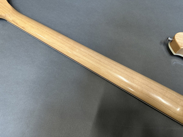 Maple guitar neck with smooth satin finish on gray background.