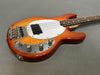 Vintage electric bass guitar with sunburst finish and white pickguard on gray background