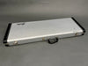 Silver vintage Fender guitar hard case with black leather corners and handle on gray background