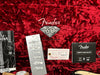 Fender 60th Diamond Anniversary guitar case interior with owner's manual, Fender hang tags, registration card, and certification on red plush lining
