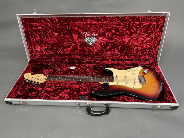Fender Stratocaster electric guitar with sunburst finish in red velvet lined Fender 60th anniversary hard case on gray background