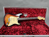 Fender Stratocaster electric guitar in sunburst finish with rosewood fretboard resting in red velvet-lined hardshell guitar case with Fender 60th anniversary logo inside lid.