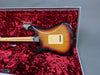 Fender Stratocaster electric guitar back body close-up in sunburst finish inside red velvet-lined hard case with Fender 60th anniversary logo