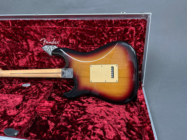 Fender Stratocaster electric guitar back body close-up in sunburst finish inside red velvet-lined hard case with Fender 60th anniversary logo