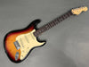 Fender Stratocaster electric guitar with sunburst finish, maple neck, rosewood fingerboard, and three single-coil pickups on gray background