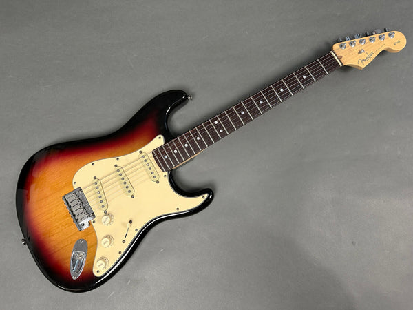 Fender Stratocaster electric guitar with sunburst finish, maple neck, rosewood fingerboard, and three single-coil pickups on gray background
