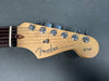 Fender Stratocaster guitar headstock with chrome tuning pegs and "Sixty Years" decal on natural wood finish against gray background