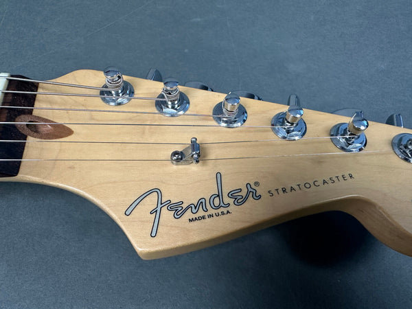 Close-up of Fender Stratocaster guitar headstock with chrome tuning pegs and "Made in U.S.A." text on maple wood background