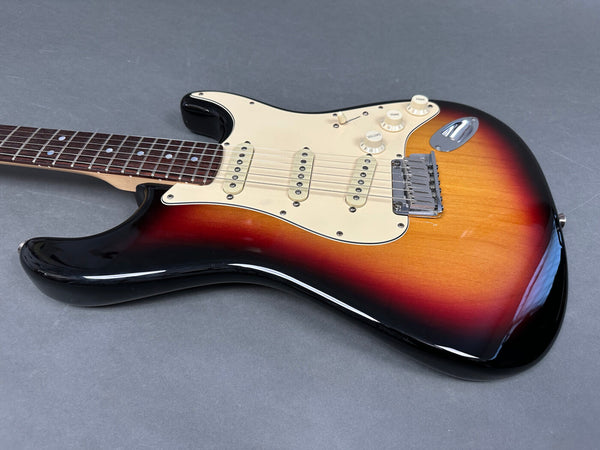 Sunburst electric guitar with three single-coil pickups and rosewood fretboard on gray background