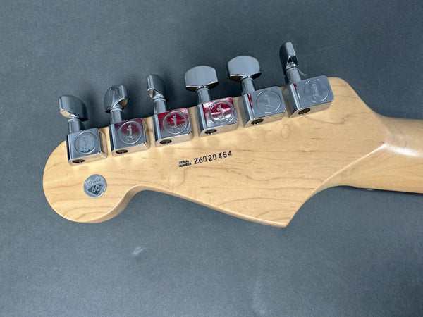 Fender guitar headstock back showing chrome tuning pegs, serial number Z6020454, and Fender 60th anniversary medallion on natural maple wood.