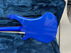 Back side of electric guitar with glossy blue finish resting in a dark blue plush guitar case