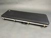 Black hard shell guitar case with silver latches and handle for electric guitar storage and transport