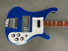 Blue electric bass guitar with white pickguard and chrome bridge hardware, wooden fretboard with triangular inlays, four control knobs, and toggle switch on gray background