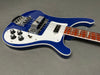 Blue electric bass guitar with white pickguard and four control knobs on gray background, featuring chrome bridge and pickups and a rosewood fingerboard