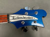 Close-up of blue Rickenbacker electric bass guitar headstock with four tuning pegs and Rickenbacker logo plate, made in USA visible on neck.