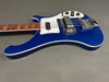 Blue electric bass guitar with white pickguard, chrome hardware, and rosewood fretboard on gray background