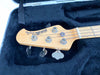 Maple neck and headstock of Squier by Fender PJ Bass guitar with chrome tuning pegs in black plush guitar case