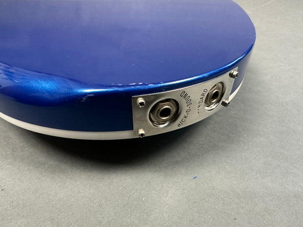 Close-up of blue Mick-O-Sound guitar input jack plate with dual input sockets on gray background