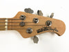 Close-up of Ernie Ball Music Man StingRay bass guitar headstock with tuning pegs and strings on a white background