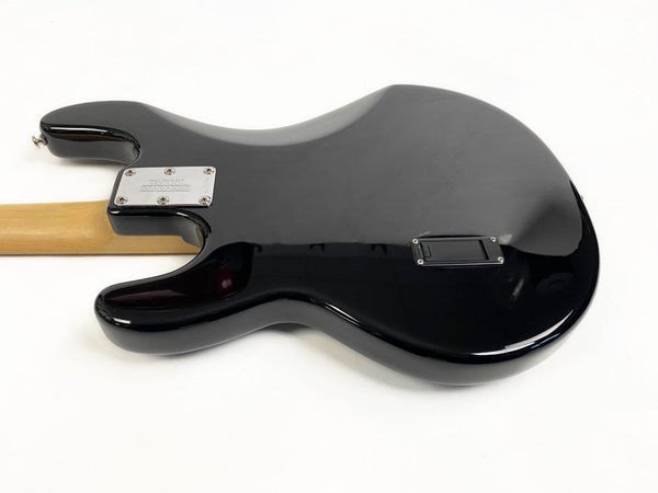 Black electric guitar body back with maple neck and chrome neck plate on white background