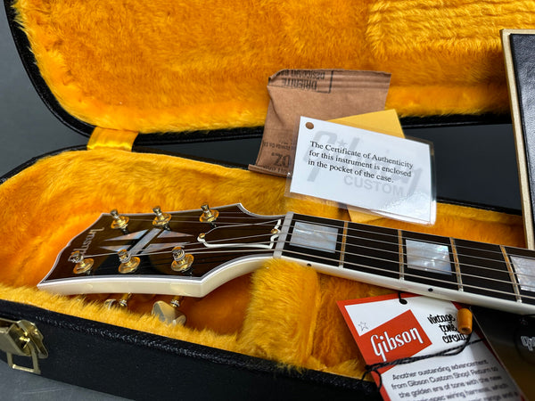 Gibson guitar headstock and neck detail inside plush yellow guitar case with Certificate of Authenticity and Gibson vintage tone circuit tag