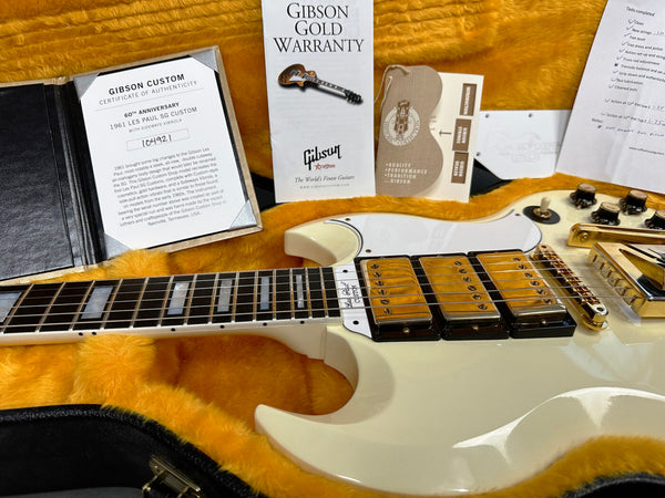 1961 Gibson Les Paul SG Custom Vintage White electric guitar with sideways vibrola in orange plush guitar case, showing certificate of authenticity, Gibson Gold Warranty, and service checklist