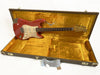 1962 Fender Stratocaster electric guitar in red finish with vintage gold pickguard, displayed in open vintage-style hard case with gold plush interior lining