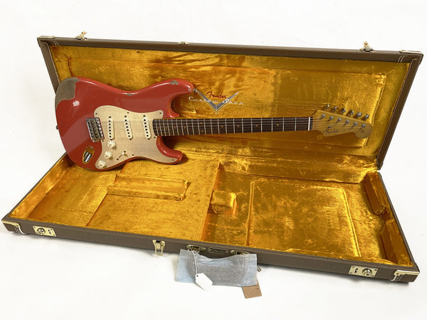 1962 Fender Stratocaster electric guitar in red finish with vintage gold pickguard, displayed in open vintage-style hard case with gold plush interior lining