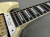 Close-up of Les Paul Custom electric guitar fretboard with mother of pearl block inlays and gold hardware on cream body