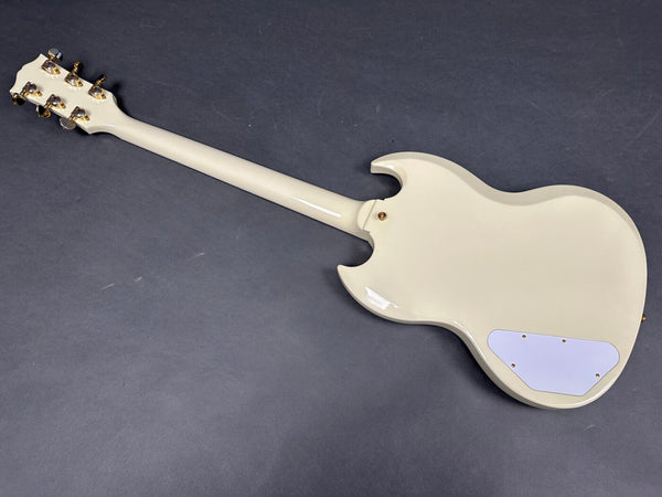 White electric guitar back view showing neck, gold tuning pegs, and control cavity cover on dark gray background