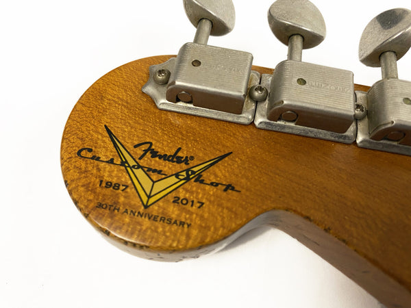 Close-up of Fender Custom Shop 30th Anniversary 1987-2017 logo and vintage tuning pegs on guitar headstock with worn wood finish