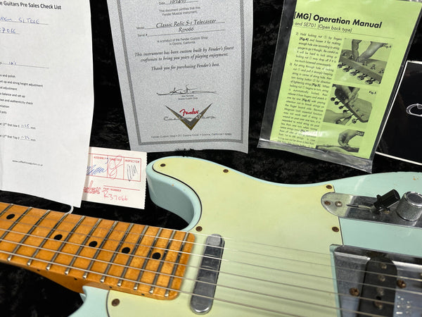 Fender Classic Relic S-1 Telecaster guitar with custom shop certificate, pre-sales checklist, green MG operation manual, and close-up of the guitar's maple fretboard and vintage-style pickguard.