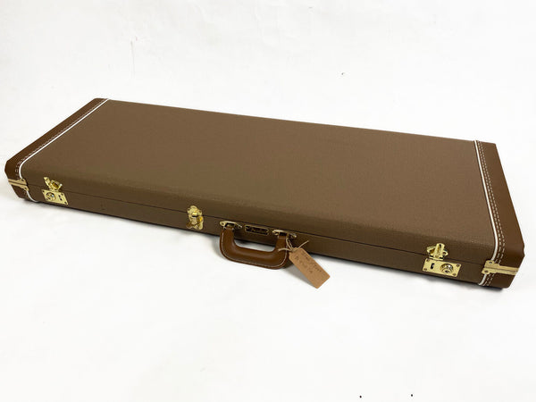 Brown Fender hard guitar case with gold latches and leather handle on white background