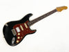 Black Fender Stratocaster electric guitar with tortoiseshell pickguard, rosewood fretboard, and vintage wear and finish chips