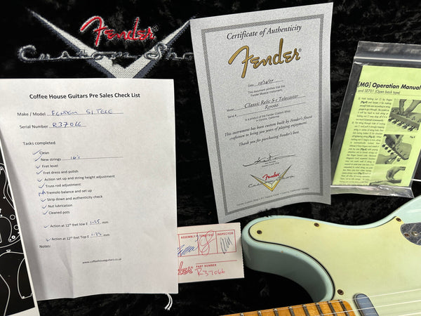Fender Custom Shop guitar authenticity certificate, Coffee House Guitars pre-sales checklist for Fender S1 Telecaster, instruction manual, and part of a light blue Fender Telecaster guitar body on black background