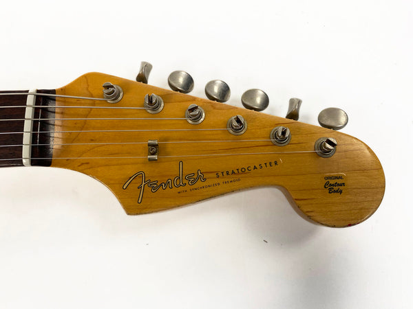 Close-up of Fender Stratocaster guitar headstock with six tuning pegs and "Original Contour Body" logo on natural wood finish