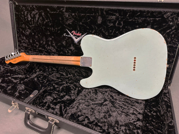 Back view of Fender Telecaster guitar in light blue finish with visible wear, resting inside black plush-lined Fender custom shop guitar case