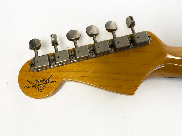 Close-up of Fender Custom Shop guitar headstock with vintage tuning pegs on natural wood finish neck