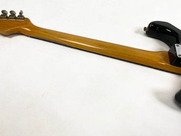 Back view of guitar neck with natural wood finish and chrome tuning pegs on plain white background