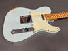 Vintage light blue electric guitar with maple fretboard and white pickguard showing wear and aging details