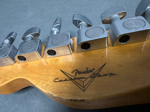Close-up of Fender Custom Shop guitar headstock with chrome tuning pegs on natural wood finish