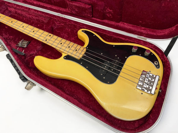 Vintage yellow electric bass guitar with black pickguard inside red velvet lined hard case