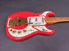 Burns London electric guitar in bright red with white pickguard, gold hardware, three single-coil pickups, and maple neck, photographed on gray background