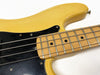 Close-up of vintage yellow electric bass guitar fretboard and strings with black pickguard against white background