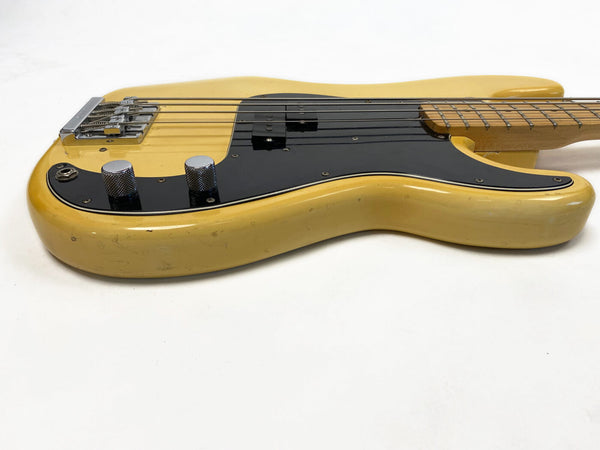 Vintage yellow electric bass guitar with black pickguard and chrome control knobs on white background