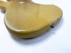 Close-up of vintage yellow electric guitar body with visible wear and paint chips on white background