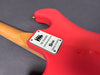 Close-up of red electric guitar back with wooden neck and metal plate reading "The Shadows Custom Edition Burns London Serial No 0378" on gray background