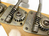 Close-up of vintage Fender bass guitar tuning pegs and gears on natural wood headstock
