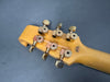 Close-up of vintage Burners guitar natural wood headstock with metal tuning pegs on gray background